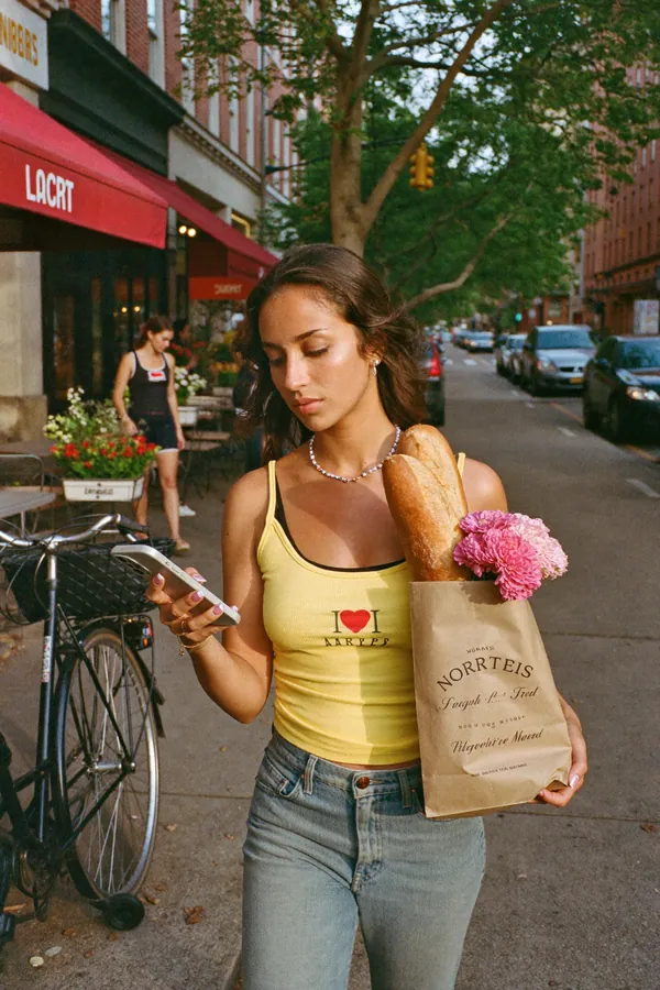 A woman with groceries walking down a Brooklyn street